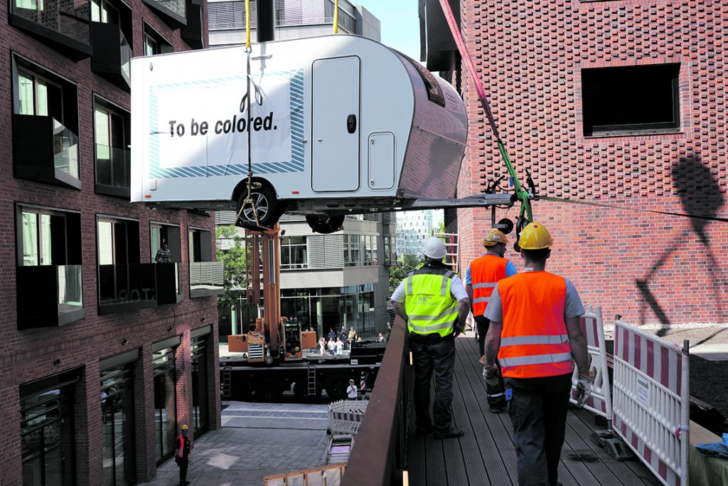 Einer von drei Pierdrei-Wohnwagen schwebt in die „Camper City“ auf die Terrasse im 1. OG des neuen Pierdrei-Hotels ein. Foto: Thomas Hampel