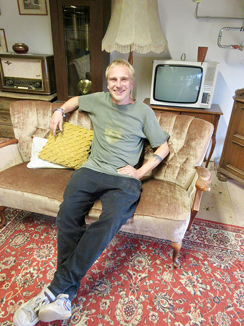Parkour-Betreiber Sebastian „Batte“ Ploog hat es sich im sogenannten Wohnzimmer im ersten Stock auf einem Sofa bequem gemacht. Foto: Dagmar Leischow