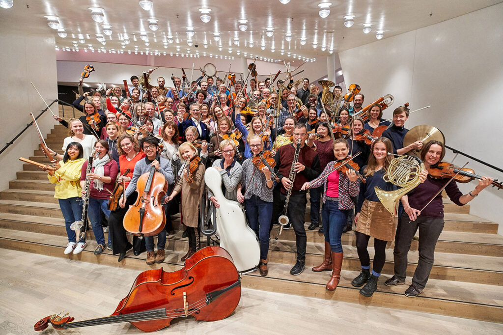 Ansteckende Spielfreude und mitreißende Stücke im Elbphilharmonie-Unikat auf dem Hope‘n‘Air-Outdoor-Festival: Rund 90 begeisterte Laien spielen im Publikumsorchester der Elbphilharmonie auf hohem Niveau. Jede Saison erarbeiten sie neue Werke, die sie im Großen Saal und in Hamburger Stadtteilen dem Publikum präsentieren. © Claudia Höhne | Elbphilharmonie