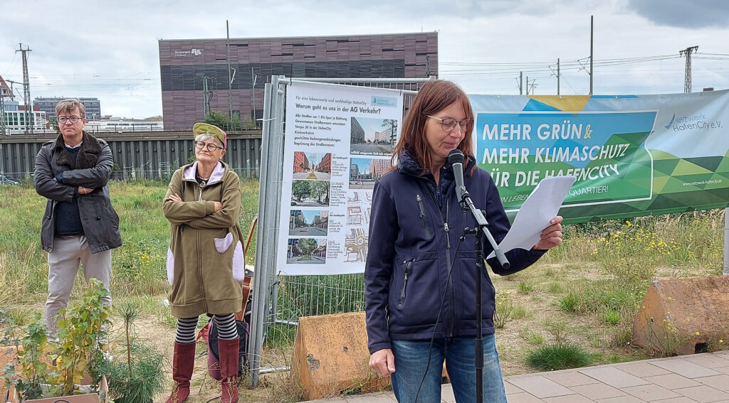 Marianne Wellershoff vom Netzwerk HafenCity e. V., rechts. Im Hintergrund Liedermacherin Feli Rockt und Arne Platzbecker (SPD) auf dem Baufeld 74 in der HafenCity am 19. September 2021. © Matthias Schinck